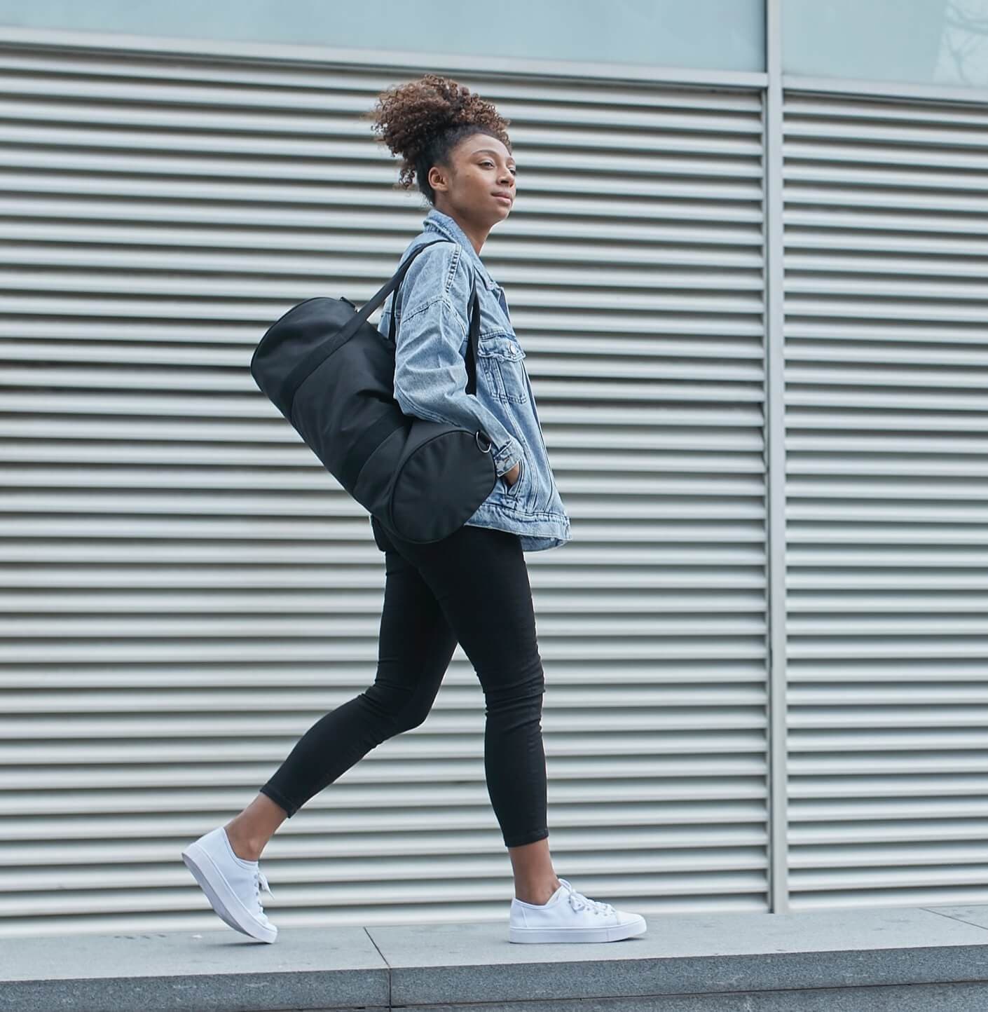 Person walking with a gym bag on their shoulder